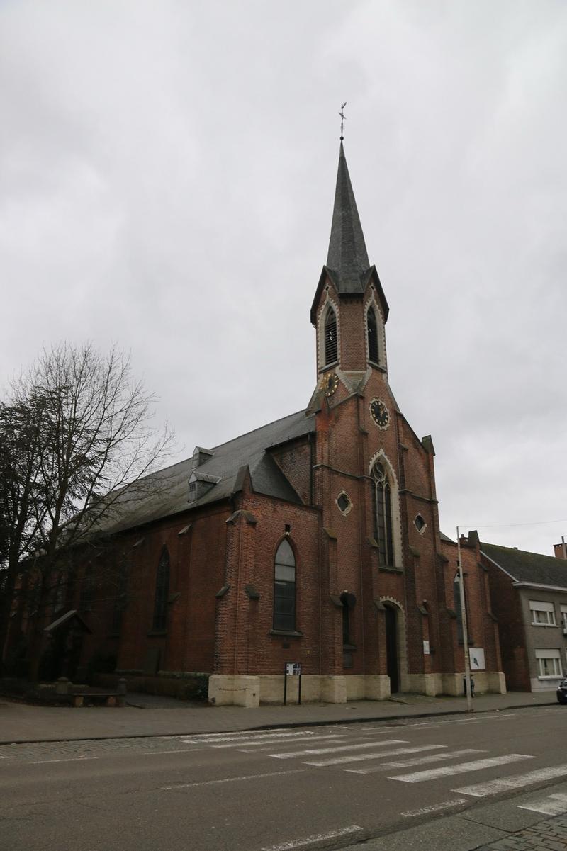De bakstenen Sint-Jan-Evangelistkerk met spitse toren in Koningshooikt