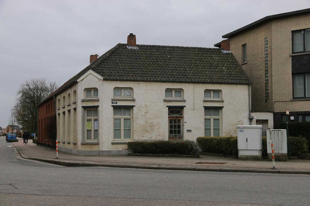 Een witgeschilderde dorpswoning op een straathoek in Koningshooikt
